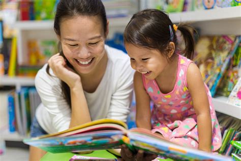 Parent and child reading books together in the library. - CERIC