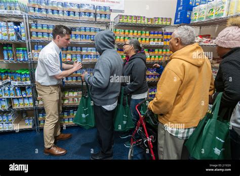 A Mormon missionary assists a client at the Catholic Charities Bronx Food Distribution Center in ...