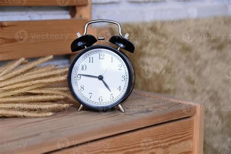 Retro Alarm Clock on wooden desk 16694075 Stock Photo at Vecteezy