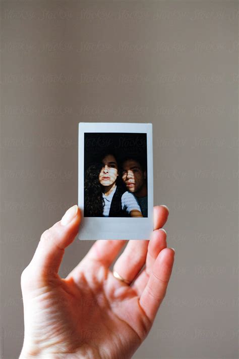 "Female Hand Holding A Polaroid Photo Of A Man And Woman Hugged" by Stocksy Contributor "Mak ...