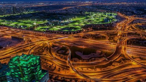 an aerial view of a city at night with many lights on the buildings and roads