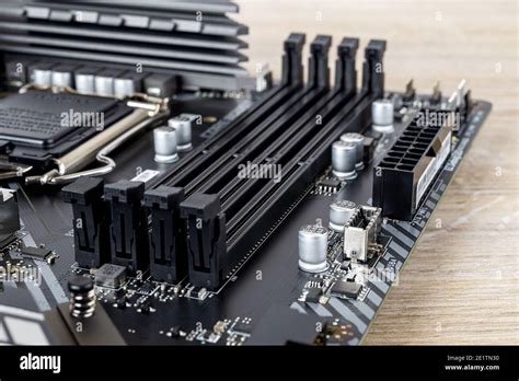 Four slots for ddr4 ram memory modules on a modern black pc motherboard. Computer mainboard ...