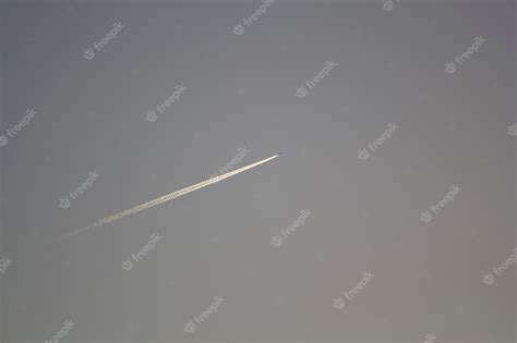 Premium Photo | A plane is flying in the sky with a trail in the sky.