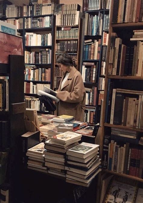 a woman standing in front of a bookshelf filled with lots of books on top of shelves