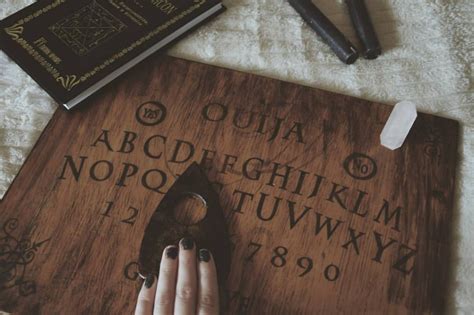 a person's hand resting on a wooden sign with letters and numbers written on it