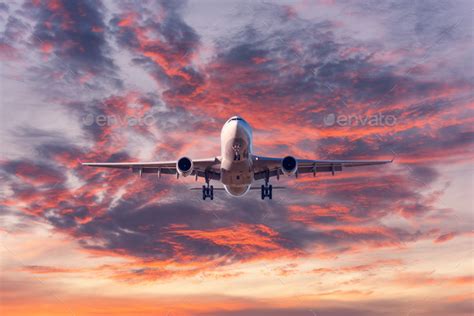 Landing passenger airplane at colorful sunset Stock Photo by den-belitsky