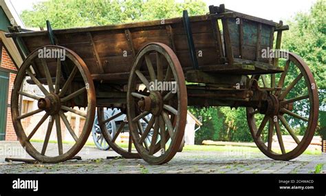 Old wooden farm wagon with traditional wheels made of wood and iron Stock Photo - Alamy