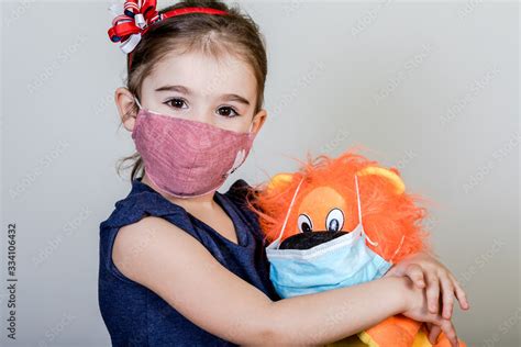 Little girl has fabric mask protect herself from Coronavirus COVID-19 Stock Photo | Adobe Stock