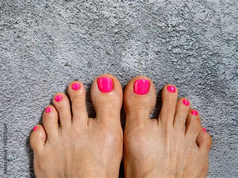 Beautiful woman's neon pink nails with beautiful pedicure. Female feet with bright pedicure on ...