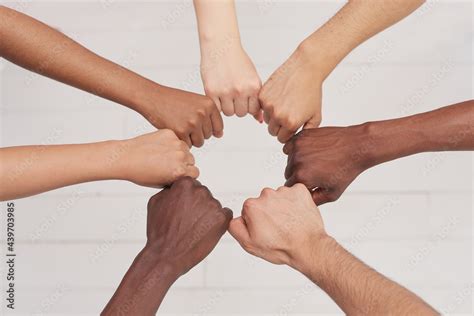 Multiethnic people holding hands in a circle together, multiethnic business team promising help ...