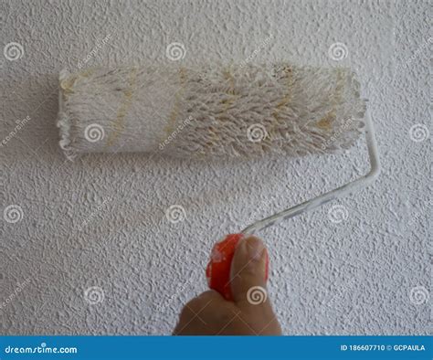 Close-up of Paint Roller Painting a White Wall. the Wall Has Popcorn Ceiling Texture. Home ...