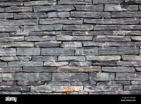 Grey stone granite wall made of stacked pieces stones. Full frame image as background Stock ...