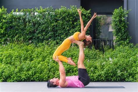 Athletic Couple Practicing Acro Yoga or Yoga Partner Together in Fitness Park Stock Photo ...