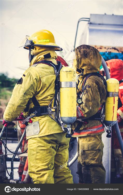 Firemen in firefighter uniform preparing equipment and tool. Stock Photo by ©kdshutterman 194939968