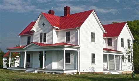 Classic white farmhouse with a red metal roof. - Celebrate & Decorate