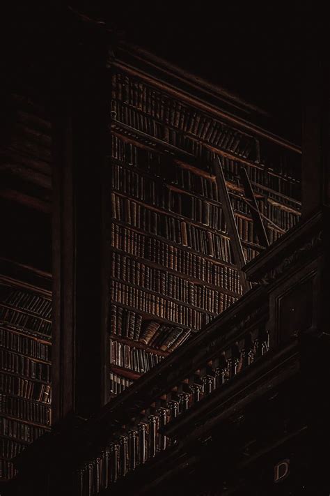 an old book shelf in the dark with books on it's sides and a clock at the top