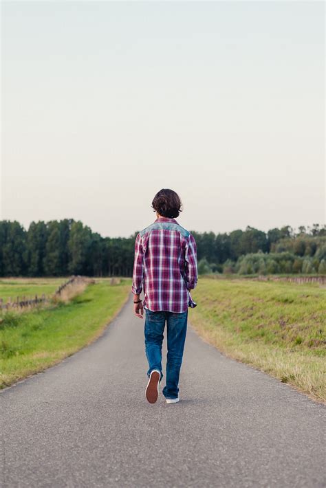 "Teenage Boy Walking Away On A Long Road In The Fields" by Stocksy Contributor "Cindy Prins ...