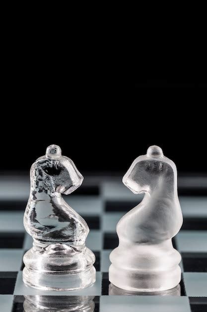 Premium Photo | Glass chess pieces on a glass chessboard with reflection.