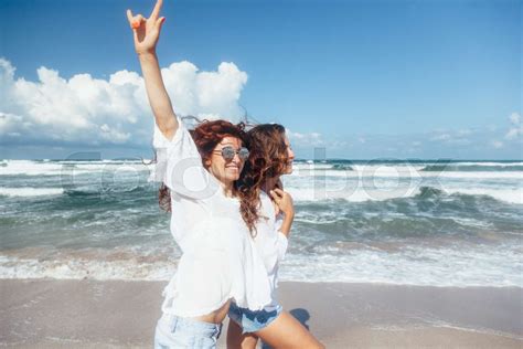 Two friends walking on the beach | Stock image | Colourbox