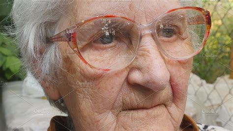 Old woman in glasses looking forward and smiling. Portrait of happy granny in eyeglasses ...