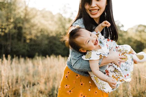 "Asian Mom And Daughter Snuggling, Cuddling, And Playing Outdoors" by Stocksy Contributor "Erin ...