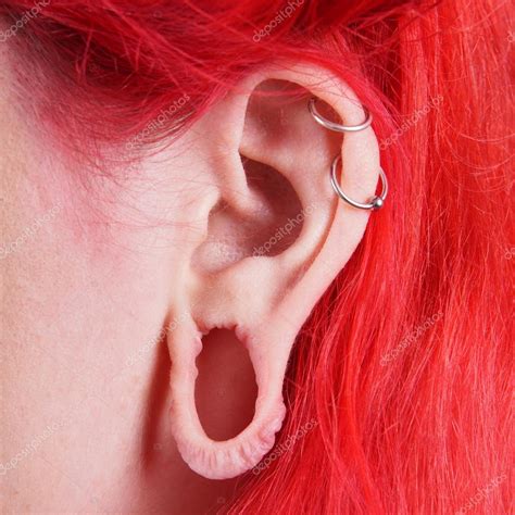 Pics: ear gauges | Stretched ear lobe piercing — Stock Photo © buecax #34388985