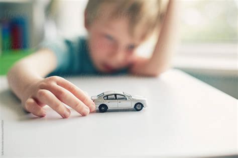 Child playing with a toy car by sally anscombe - Car, Child - Stocksy United