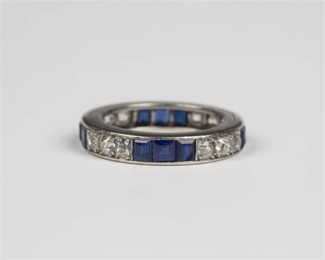 A diamond and sapphire full eternity ring, mounted with four rows of three cushion shaped diamonds,