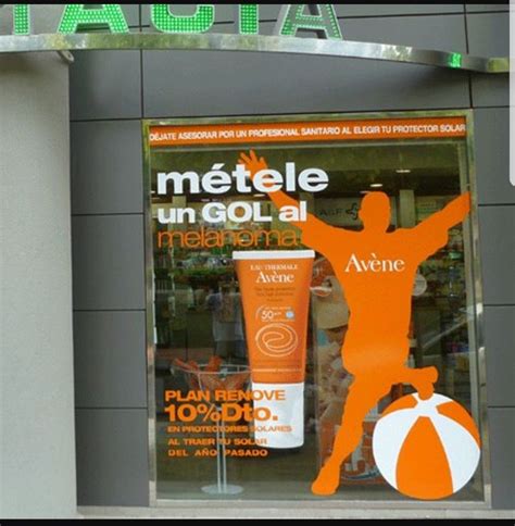 an orange and white advertisement for a sunscreenr in front of a store window