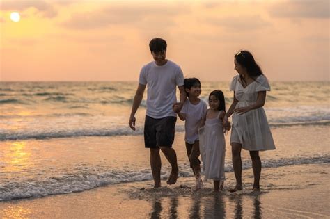 Free Photo | Asian young happy family enjoy vacation on beach in evening. Dad, mom and kid relax ...