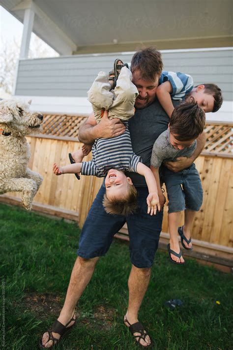 "Dad Playing With Kids In Backyard" by Stocksy Contributor "Rob And Julia Campbell" - Stocksy