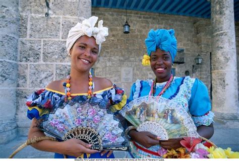 Beautiful Afro-Cuban women in their colorful traditional dress at the city of Havana in Cuba ...