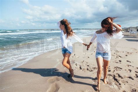 Two friends walking on the beach | Stock image | Colourbox