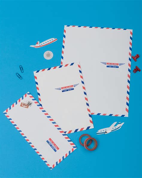 two envelopes and some scissors on a blue background with other items to make it look like an ...