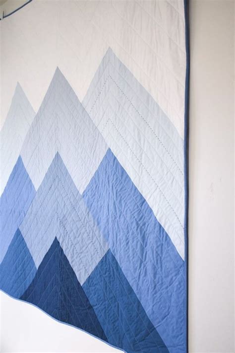 a blue and white quilt hanging on the wall