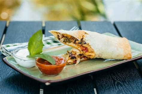 Premium Photo | Mexican burrito on plate on wooden background