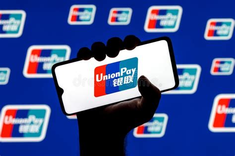 UnionPay Logo on Smartphone Screen in Clenched Hand on Background of UnionPay Logos Editorial ...