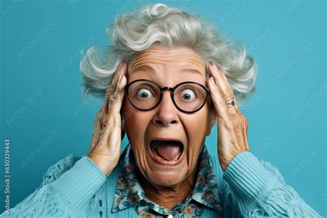 Older woman with glasses making surprised face with her hands on her head. Stock Photo | Adobe Stock