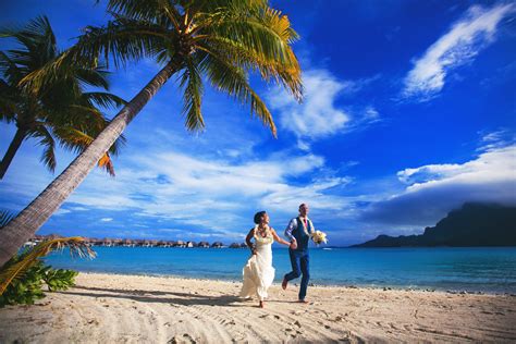 Couple running on beach in Bora Bora - photo by CALLAWAY GABLE