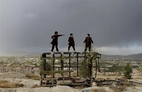 Afghanistan: Photo of 3 boys playing on destroyed vehicle above war-torn city captures life in ...