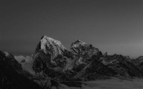 black and white photograph of mountains with clouds in the foreground, taken from an airplane