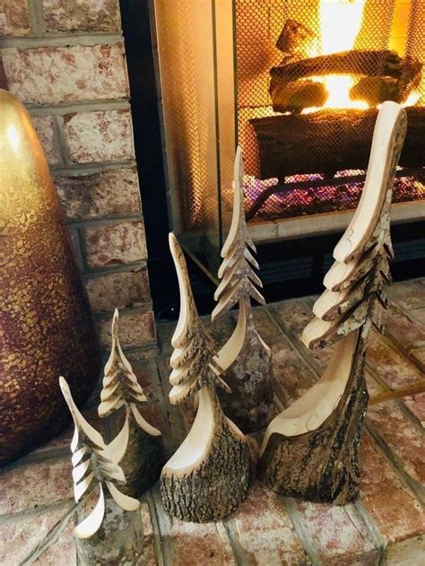 three carved wood trees sitting in front of a fireplace