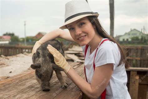 Free Photo | Farmer taking care of pigs in a sty