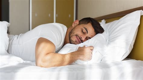 Young man peacefully sleeping in his bed – International Institute of Sleep