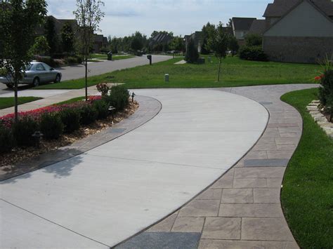 cg: Front. Blocks edging our solid driveway. Curving around side to back gate. Grass and cement ...