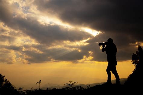 Free Photo | Silhouette of a photographer who shoots a sunset in the mountains