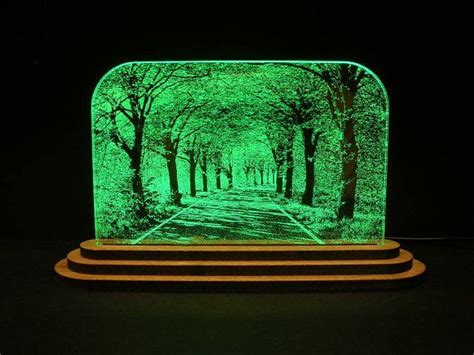 This is an edge lit L.E.D. laser engraving on acrylic with a wood base. It measures 8½ wide at ...