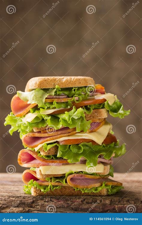 Large Shiny Sandwich with Ham Cheese and Greens on a Wooden Background Stock Photo - Image of ...