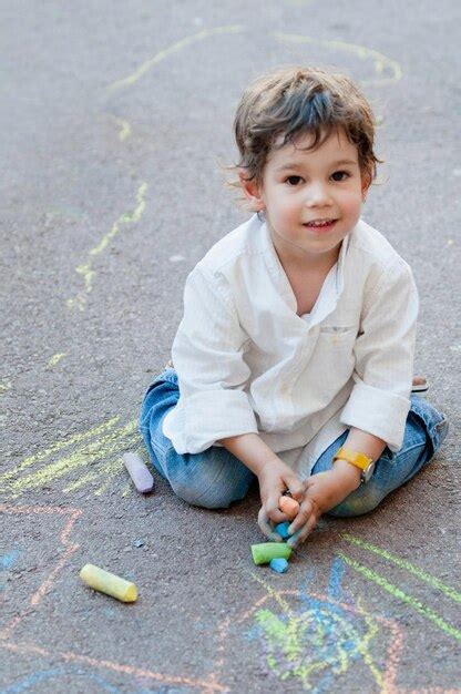 Premium Photo | Cute child drawing on the street