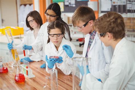 Attentive school kids doing a chemical experiment in laboratory Stock Photo by Wavebreakmedia